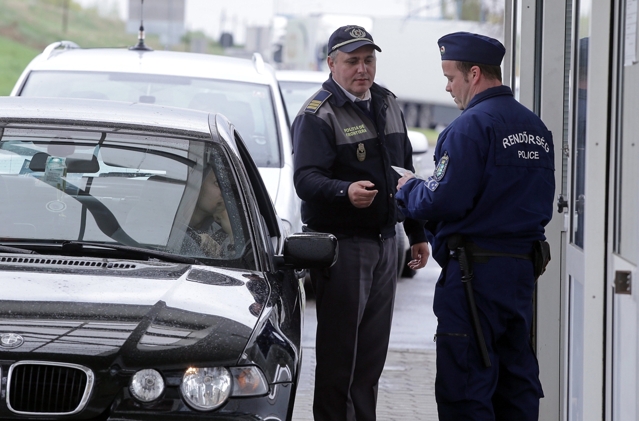 Egy belépő autós úti okmányait ellenőrzik román és magyar határőrök a gyulai magyar-román határátkelőnél (fotó: Lehocky Péter/MTI)