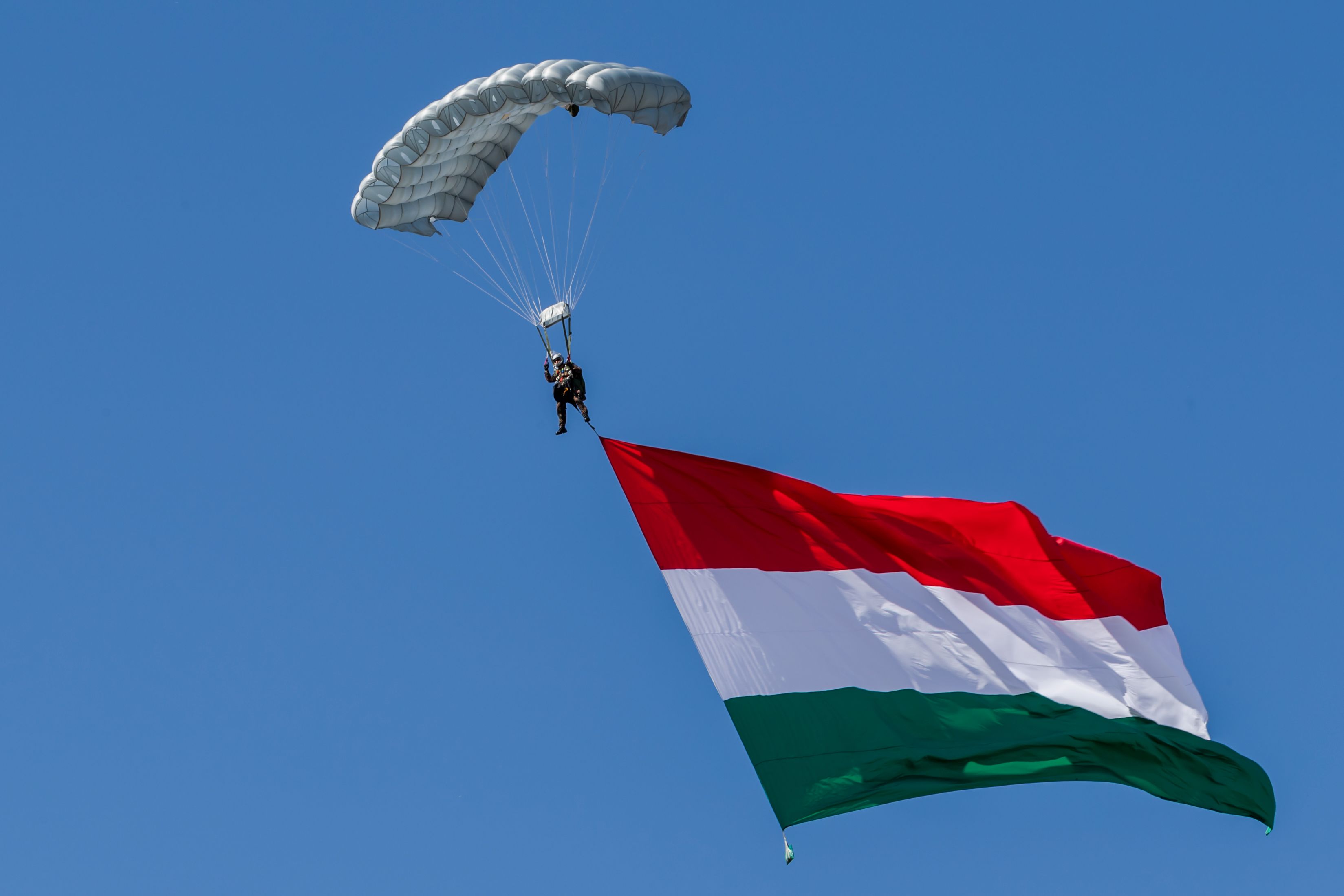 A Minyóból ugrott ejtőernyősök egyike, óriási zászló, tökéletes földetérés