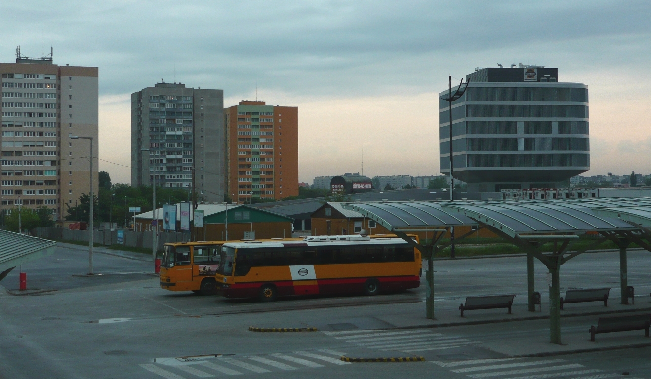 A kelenföldi buszpályaudvar, háttérben a négyes metró irányító központjával. A szomszédos vasútállomás a metró elkészültével valószínűleg átveszi a Déli pályaudvar szerepét. Ez a hatalmas intermodális csomópont kihez fog tartozni?