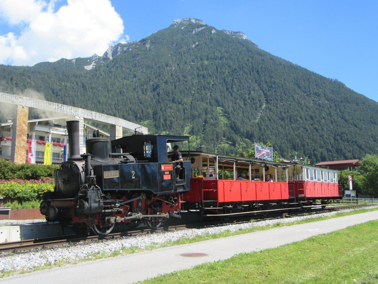 Az Achenseebahn mai napig megőrizte a 19. százád végének hangulatát. A felvételen a 2-es pályaszámú, Hermann nevet viselő mozdony kapaszkodik felfelé a kettes és az ötös kocsikkal a 2012-ben kialakított Maurach-Mitte megállónál. A képre kattintva Günter Mackinger felvételeiből készült galéria nyílik